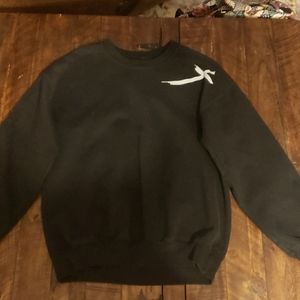 A black crew neck with Jesus has my back on the back